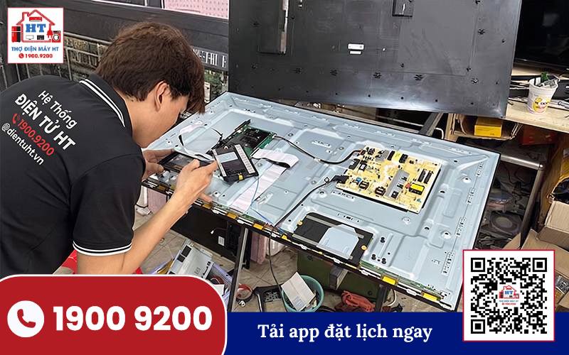 Kỹ thuật viên Điện Tử HT kiểm tra bo mạch tivi, đánh giá tình trạng để tư vấn chi phí dùng tivi 5 năm.